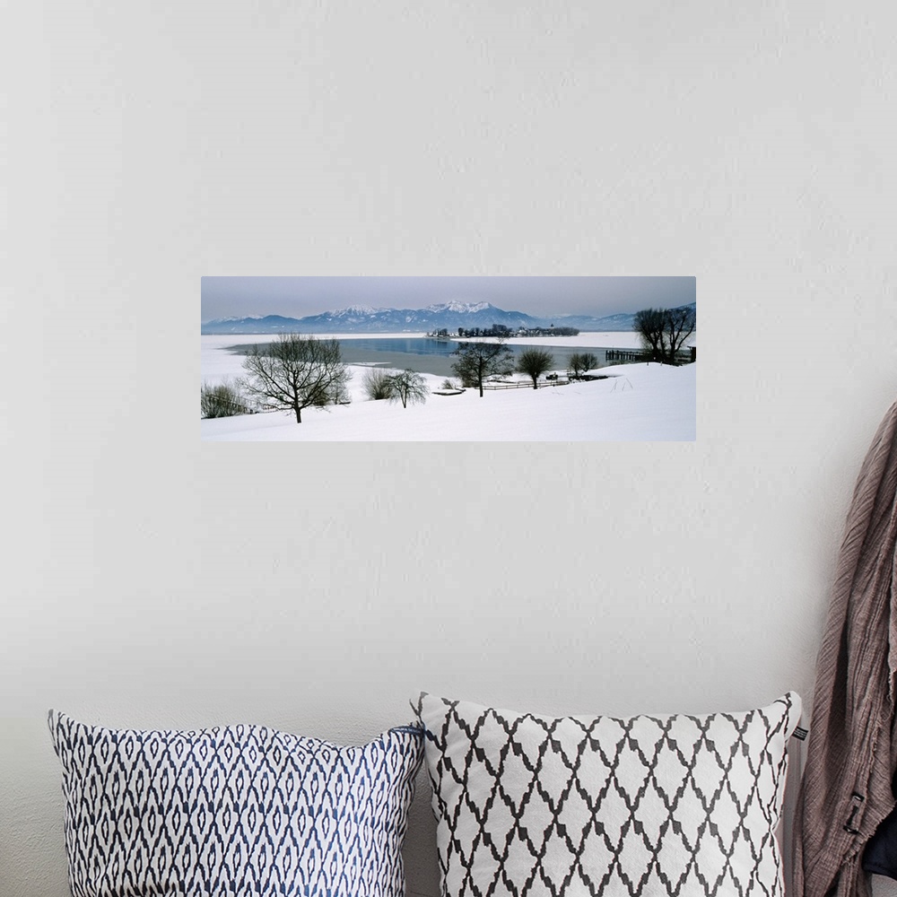 A bohemian room featuring Frozen lake in front of snowcapped mountains, Chiemsee, Bavaria, Germany