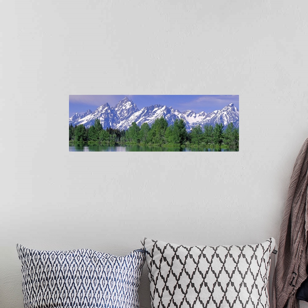 A bohemian room featuring Panoramic photograph of snow covered mountains being a line of pine trees at the waters edge, in ...