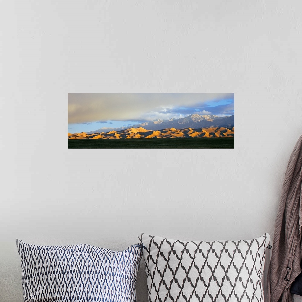 A bohemian room featuring Sand dunes in a desert with a mountain range in the background, Great Sand Dunes National Park, C...
