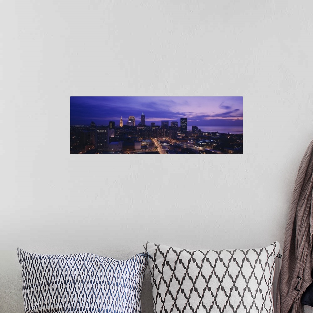 A bohemian room featuring Panoramic, large photograph from a high angle of the Cleveland skyline, with lit buildings at night.