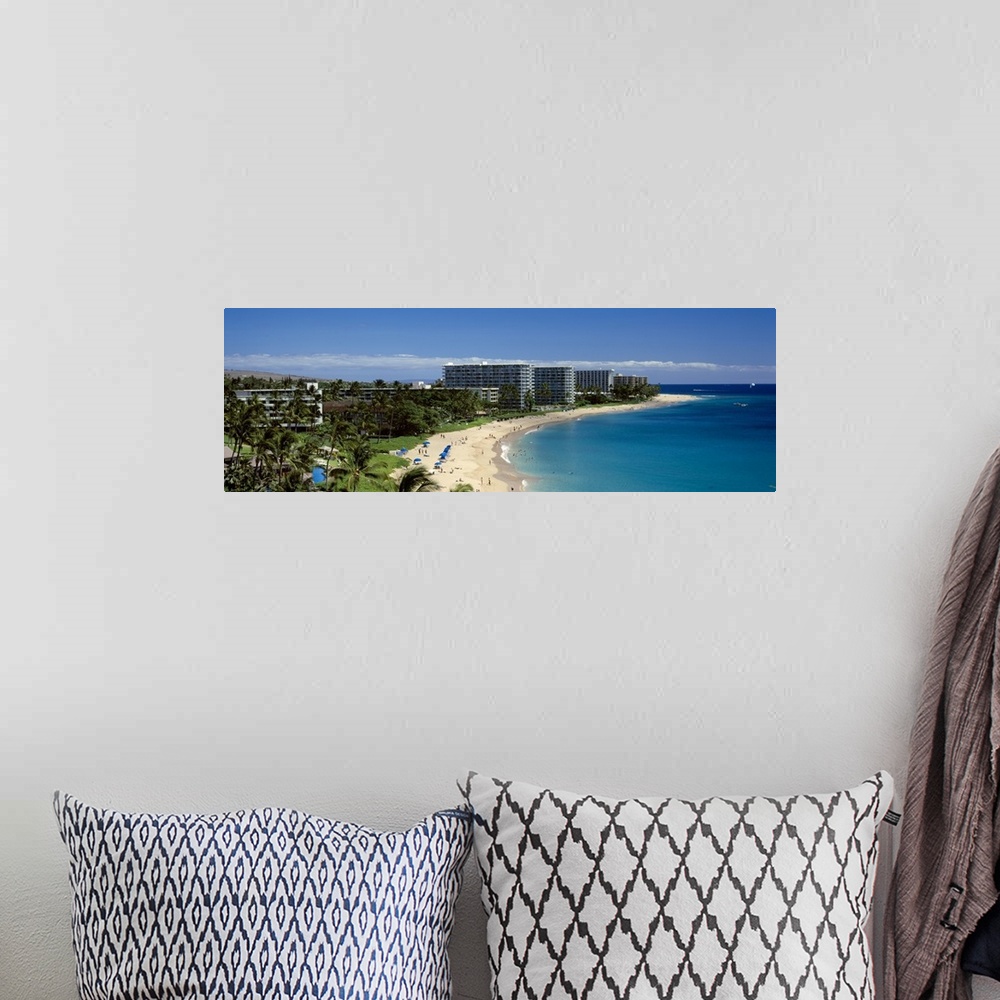 A bohemian room featuring Panoramic photograph taken of a curved coast in Hawaii that has large hotels lining it.