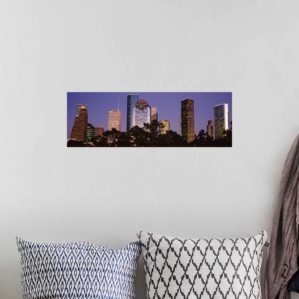 A bohemian room featuring A panoramic view of the Houston skyline with the buildings illuminated and trees that line the bo...
