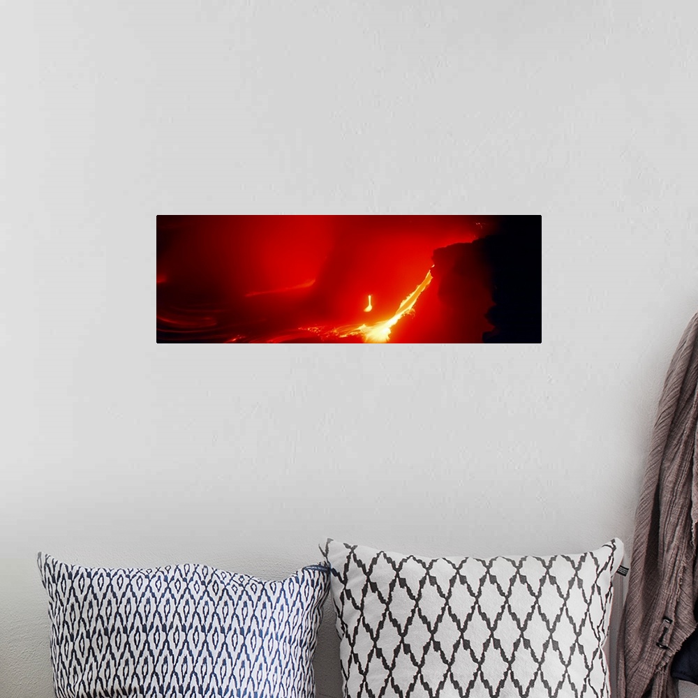 A bohemian room featuring Glowing panoramic photograph of lava flowing from domed mountain.