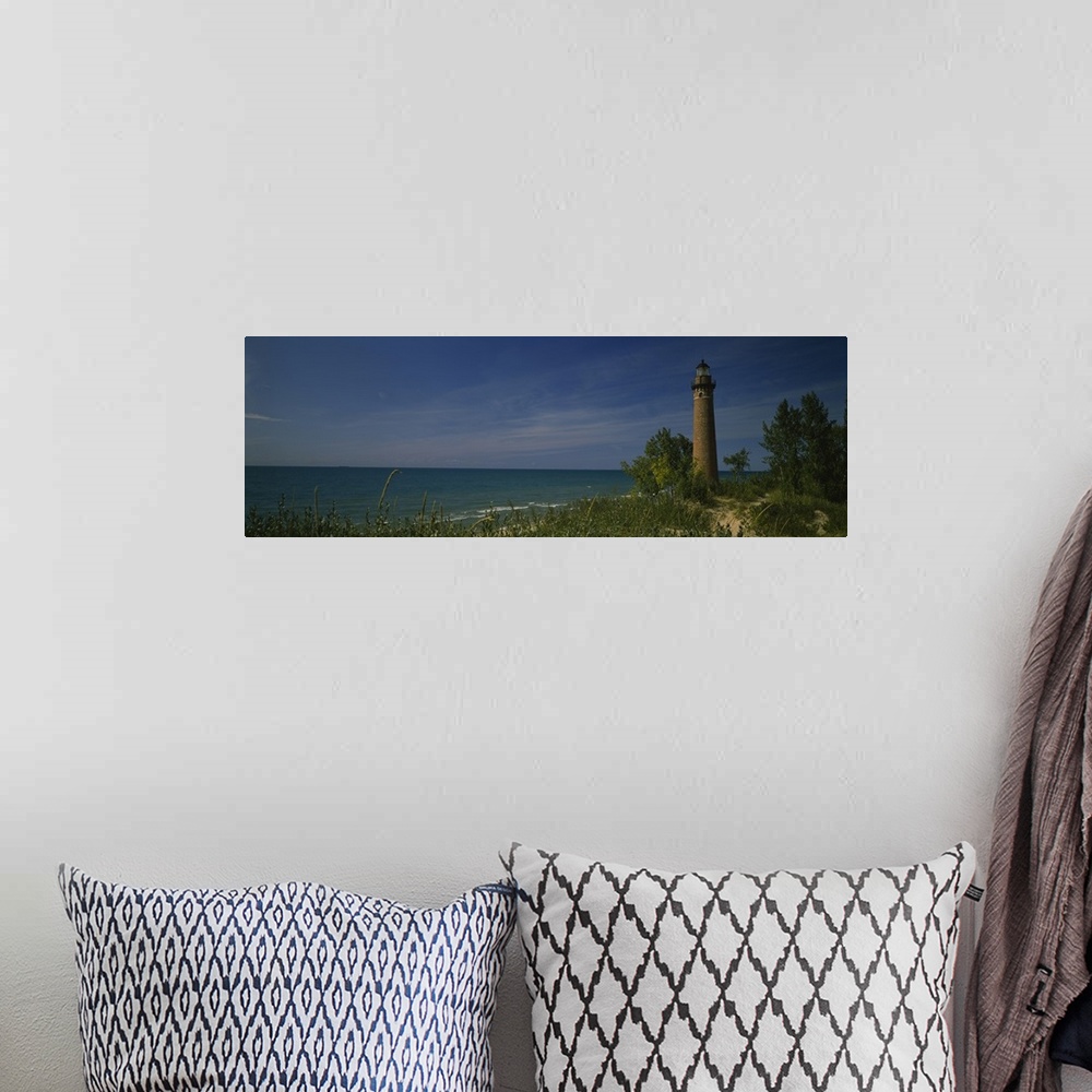 A bohemian room featuring Wide angle photograph of a lighthouse that is skewed to the right side of the picture and sits al...