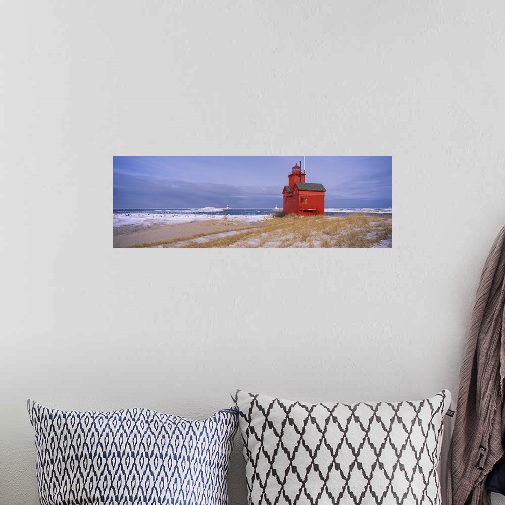 A bohemian room featuring Big horizontal photograph of the Big Red Lighthouse against a blue sky, along the coast of Lake M...