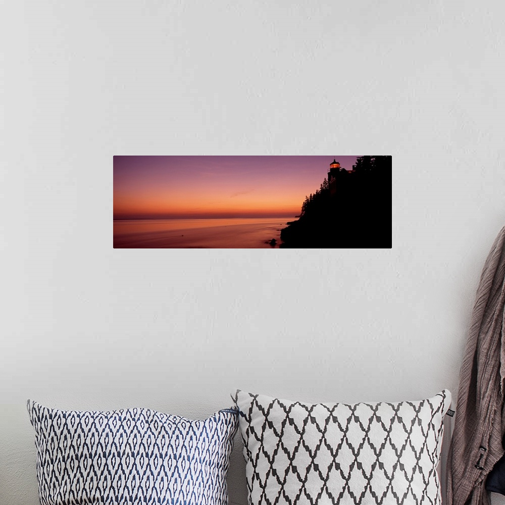 A bohemian room featuring Panoramic photograph taken during a sunset with a lighthouse shown on the right side of the pictu...