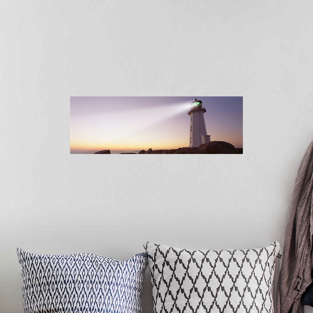 A bohemian room featuring This panoramic piece is a picture taken of a lighthouse that sits on a rocky cove and shines out ...