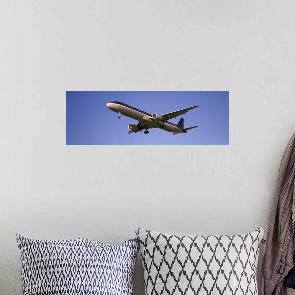 A bohemian room featuring Low angle view of an airplane flying