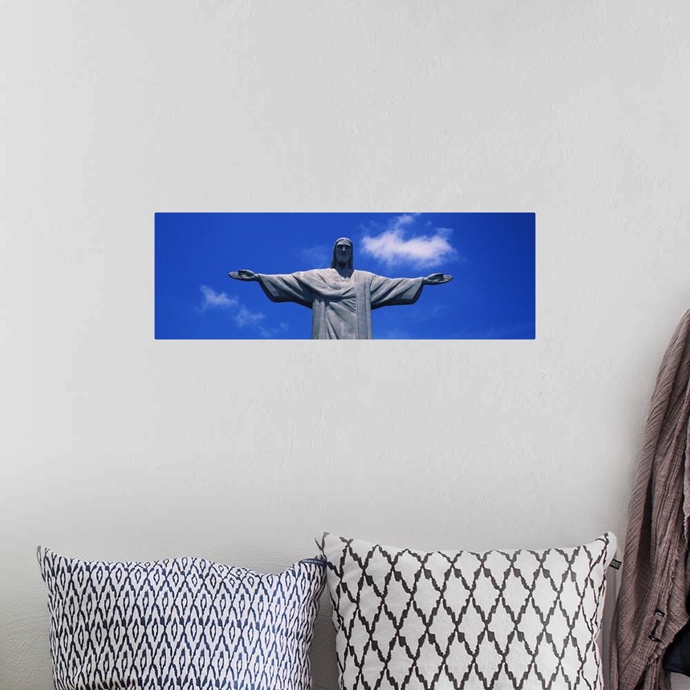 A bohemian room featuring Panoramic, low angle photograph of the Christ the Redeemer statue, from the waist up, against a b...