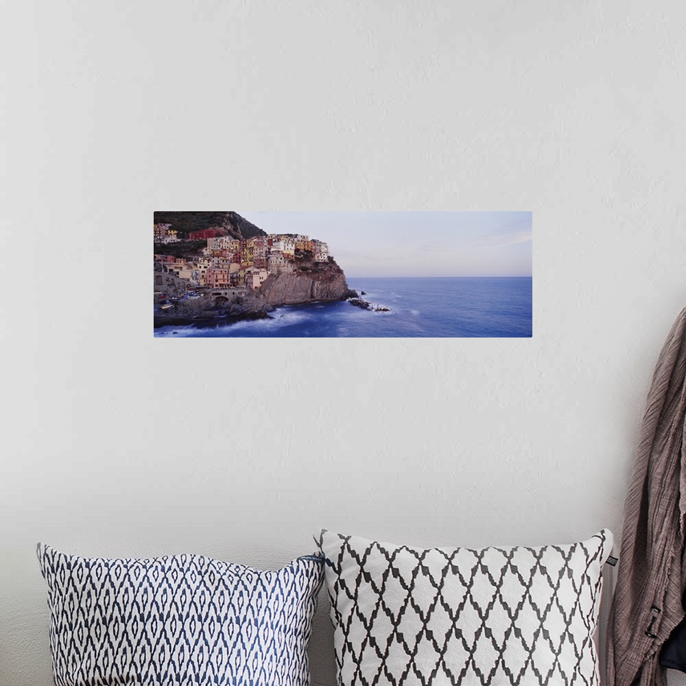 A bohemian room featuring Panoramic photograph of colorful city on cliffs overlooking ocean.