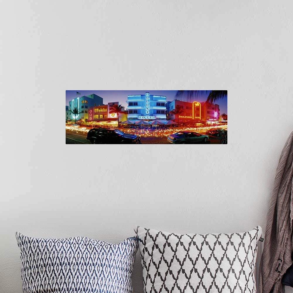 A bohemian room featuring Wide angle, giant photograph of a strip of brightly lit hotels and dance clubs at night, in Miami...