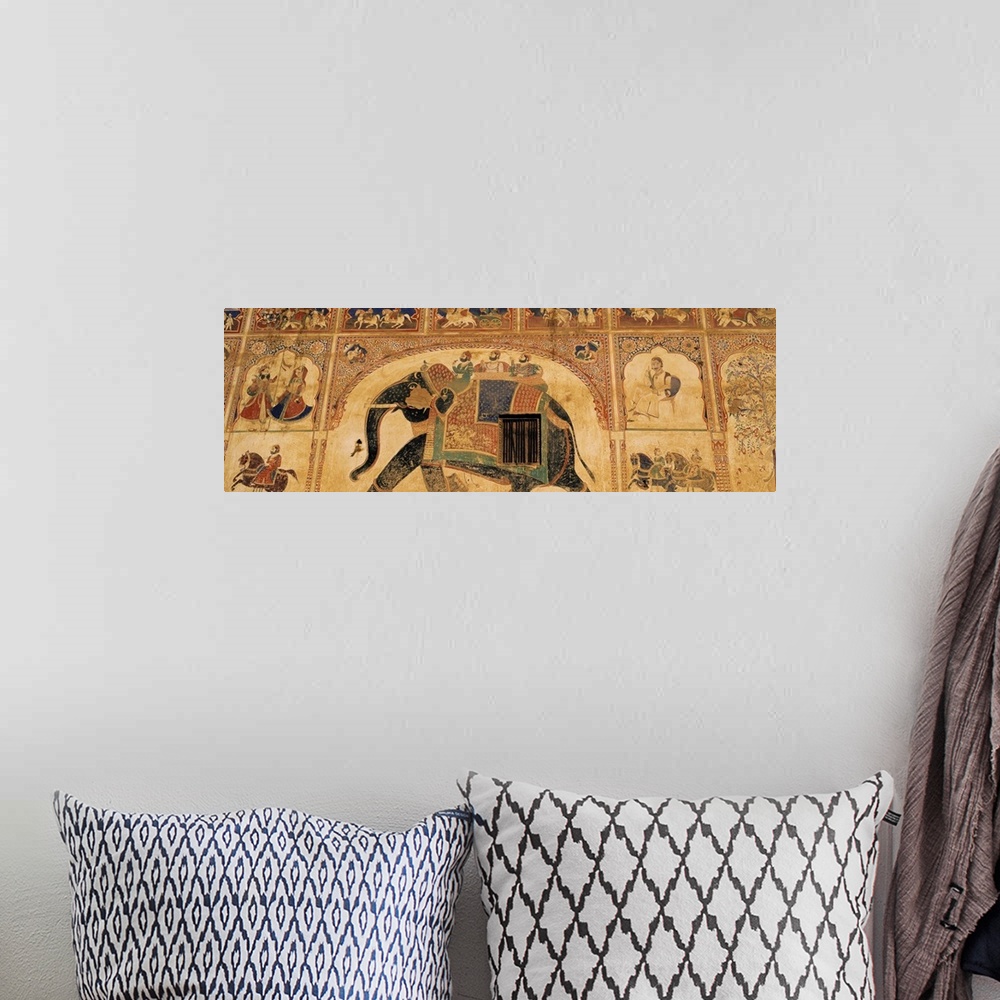 A bohemian room featuring This panoramic piece shows a large mural that has been painted on a wall in India. A large elepha...