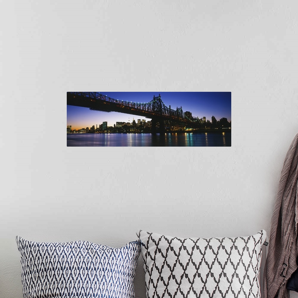 A bohemian room featuring Big, panoramic photograph of the 59th Street Bridge, lit at night, the New York City skyline in t...