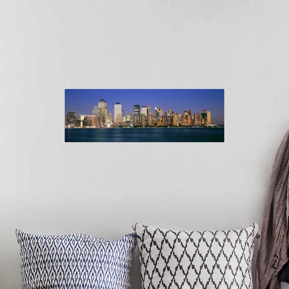 A bohemian room featuring Panoramic photograph taken of smaller skyscrapers that sit on the edge of water in New York City.