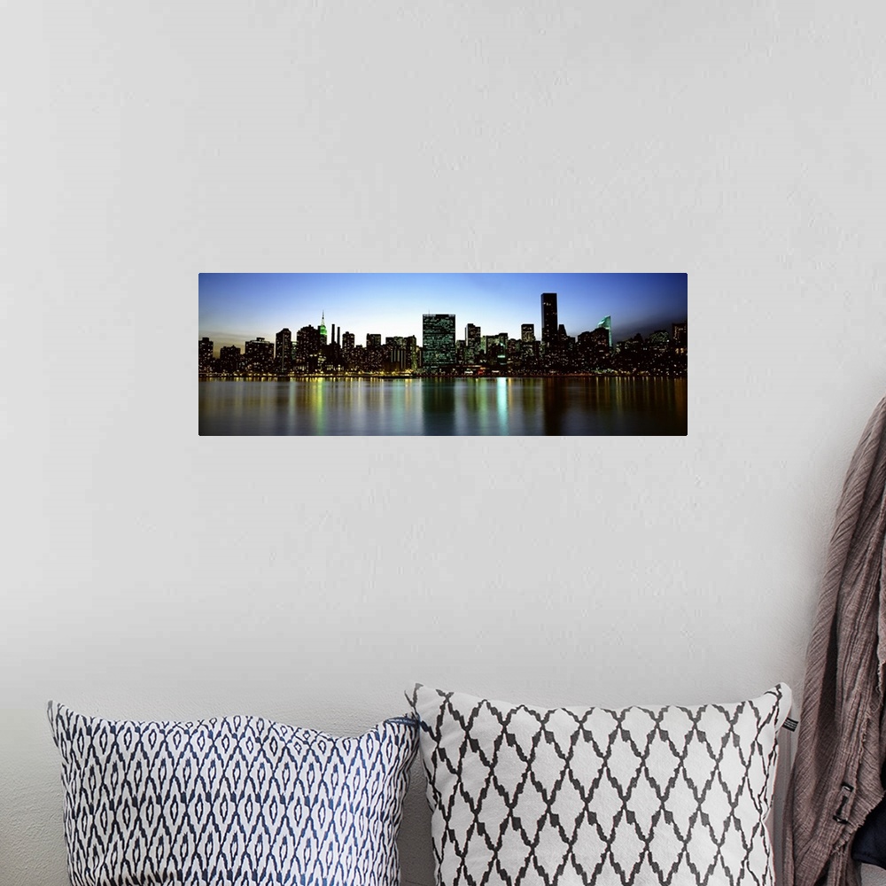 A bohemian room featuring Panoramic photograph of the New York City skyline, lit at dusk and reflecting in the waters in th...