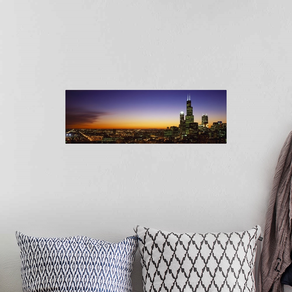 A bohemian room featuring Landscape photograph on a large wall hanging of the bright lights of the Chicago skyline at night...
