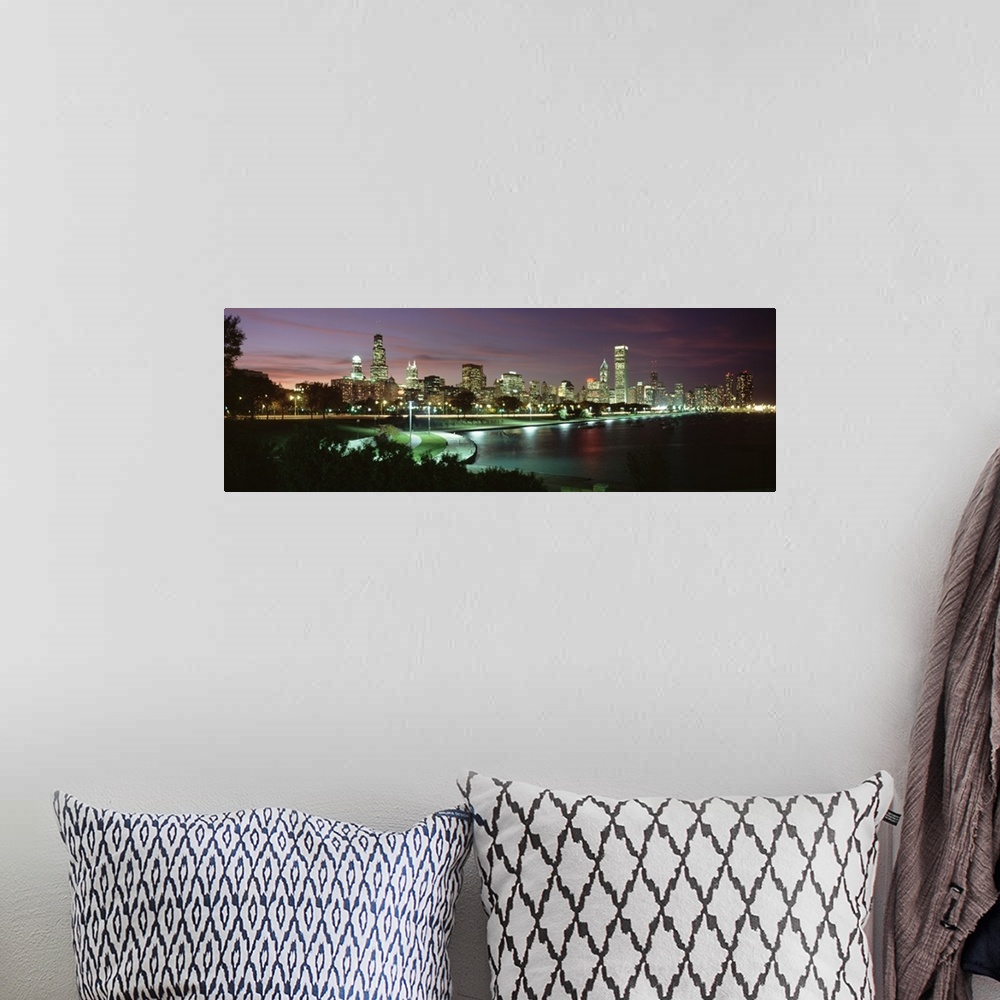 A bohemian room featuring Panoramic photograph at nighttime shows the illuminated skyscrapers and buildings that fill the s...