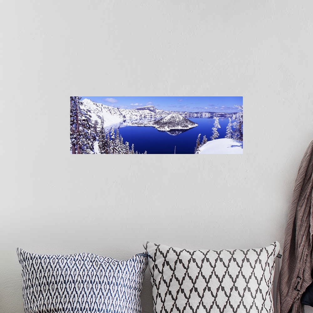 A bohemian room featuring Wide angle shot taken of Crater lake looking out toward snow covered mountains and pine trees.