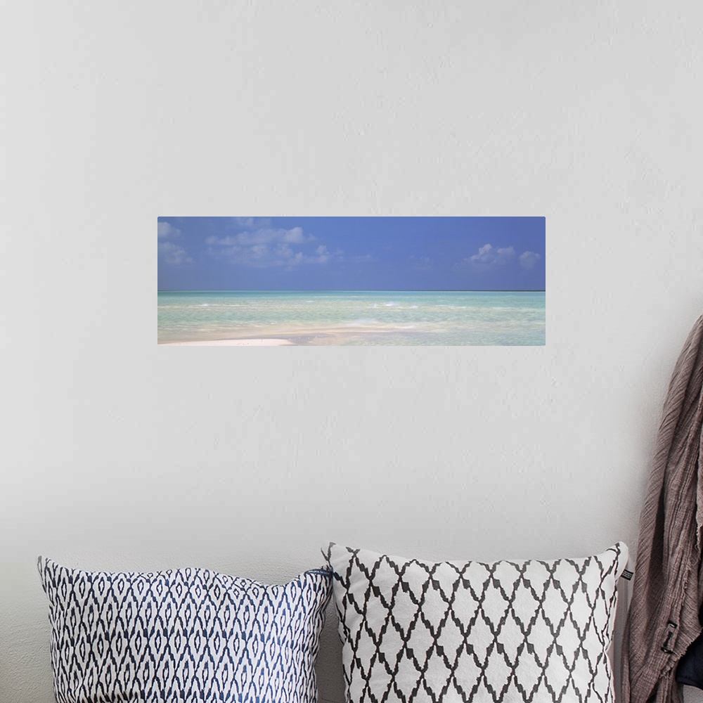 A bohemian room featuring Panoramic canvas photo of a clear ocean meeting a sandy beach.