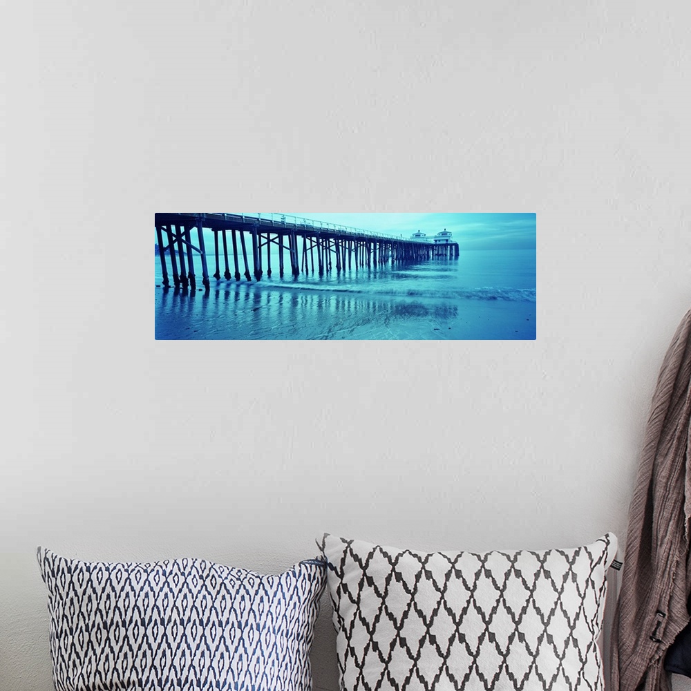 A bohemian room featuring Monotone photograph of a long pier reaching out into the Pacific Ocean at dusk with shallow waves...