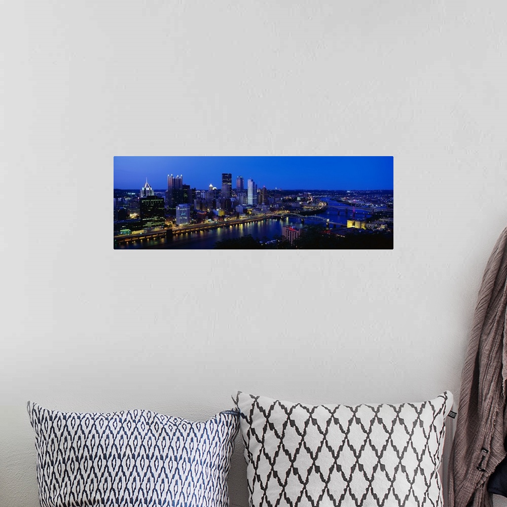 A bohemian room featuring This huge panoramic photograph is of the Pittsburg skyline at night with the buildings lit up and...