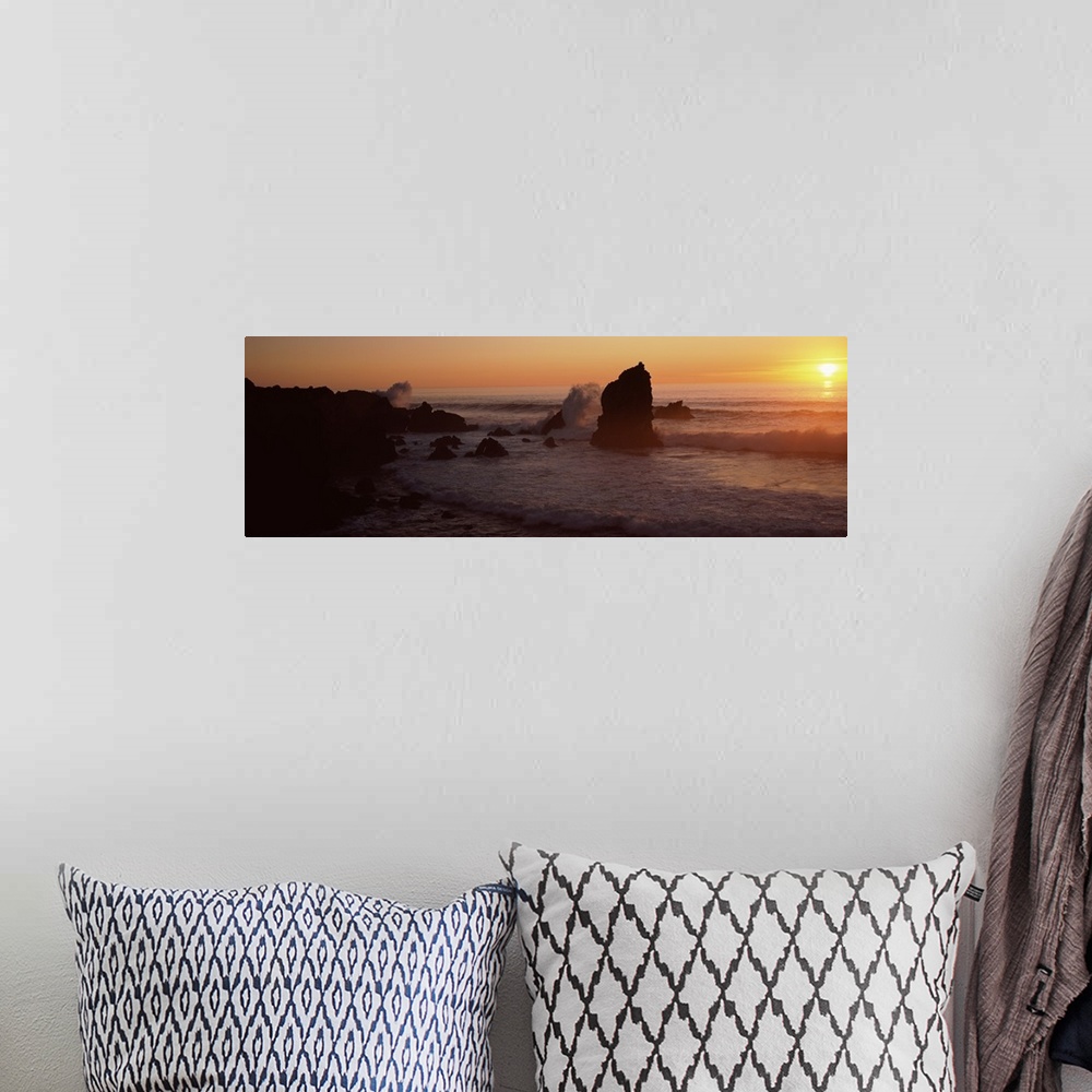 A bohemian room featuring Panoramic photo on canvas of rock formations on a beach with waves breaking on the shore at sunset.