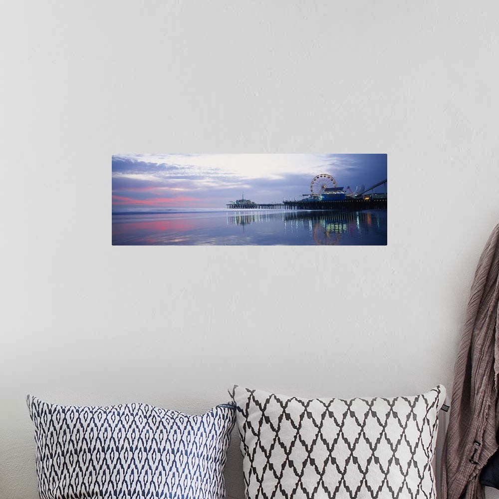 A bohemian room featuring A panoramic photograph taken at sunset showing the harbor, illuminated dock, Ferris wheel, and am...