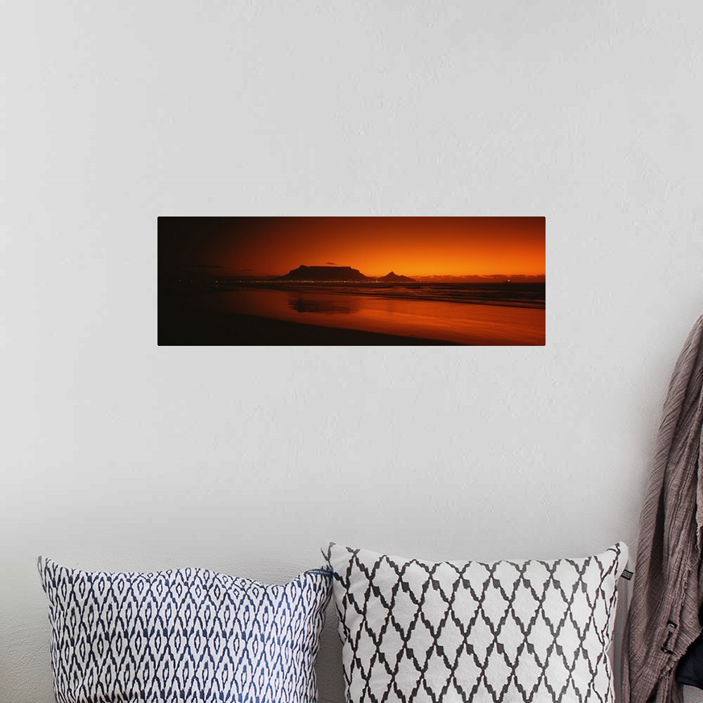 A bohemian room featuring Wide angle, large photograph of sunset at the shoreline near Table Bay in Western Cape Province, ...