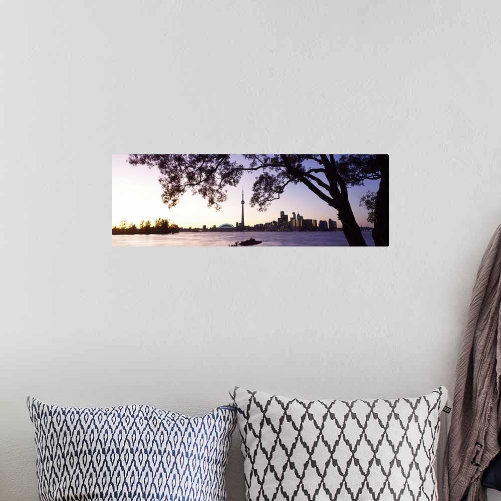 A bohemian room featuring Landscape photograph on a giant canvas of a large tree hanging over the water as the sun sets, th...