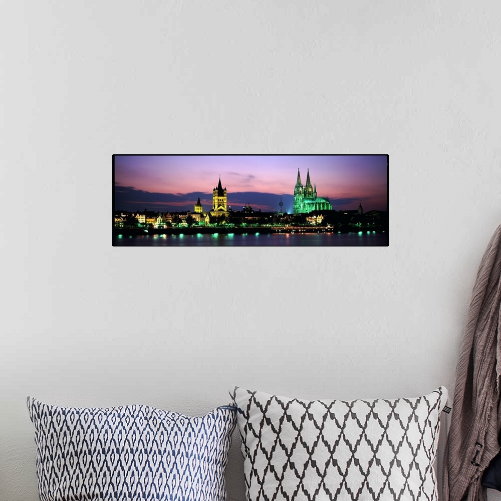 A bohemian room featuring Panoramic photo of a German cityscape lit up at night on the water.