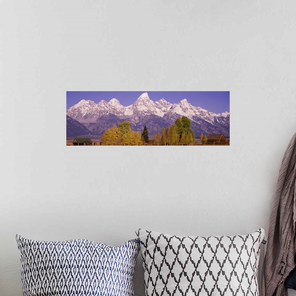 A bohemian room featuring Panoramic photograph taken of an immense mountain range that has the tops covered with snow. Some...