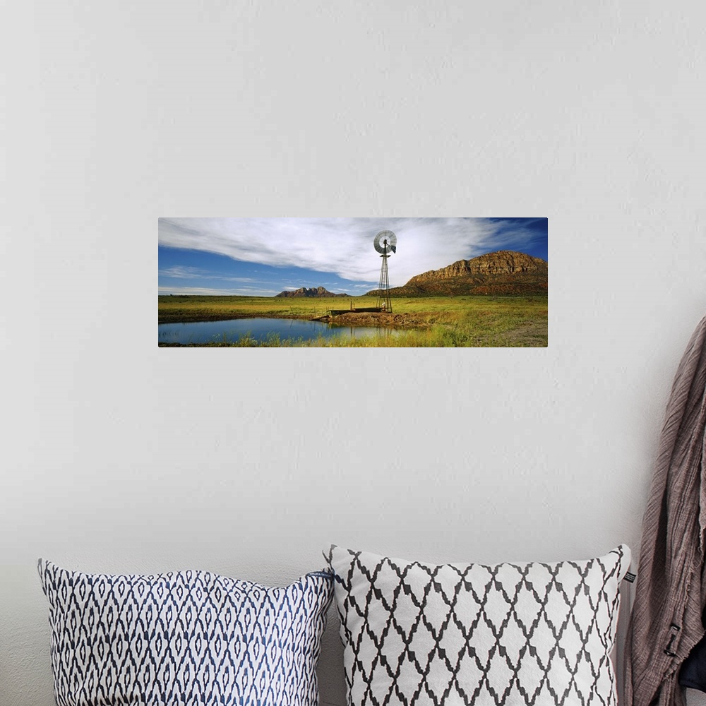 A bohemian room featuring Solitary windmill near a pond, U.S. Route 89, Utah