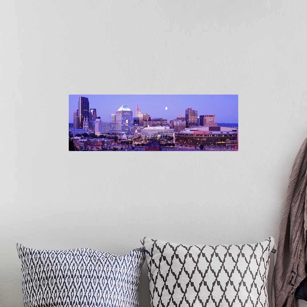 A bohemian room featuring Panoramic photograph of skyline lit up at dusk with moon in the sky.