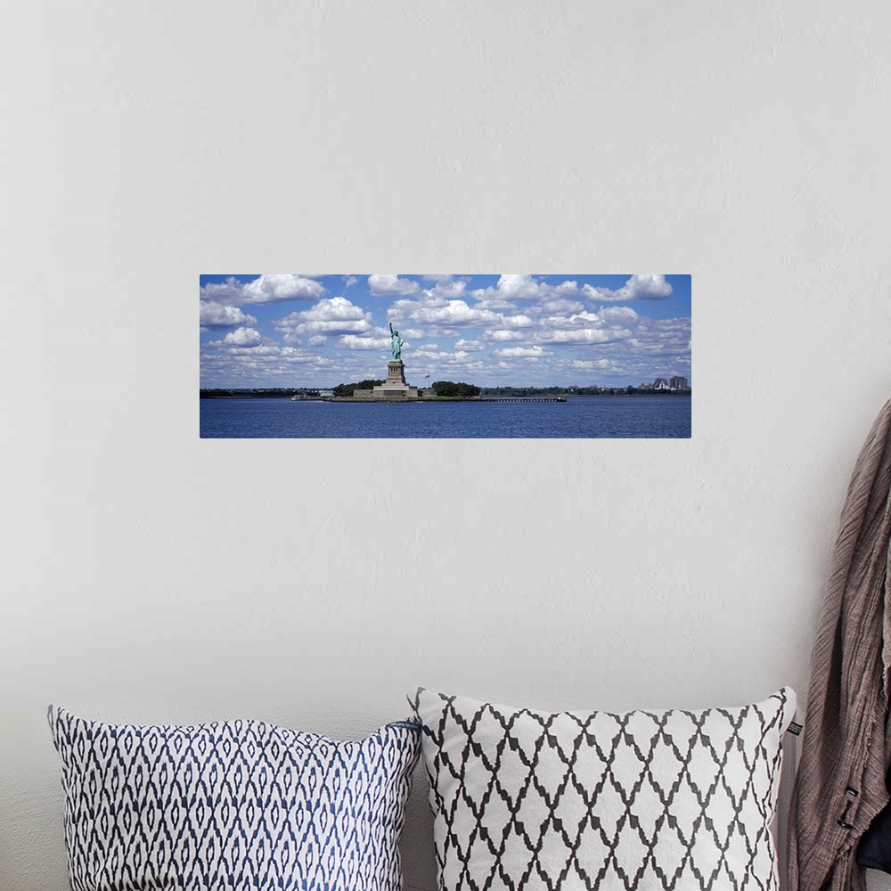 A bohemian room featuring A panorama of the Statue of Liberty and the NY Harbor with a blue sky in background.