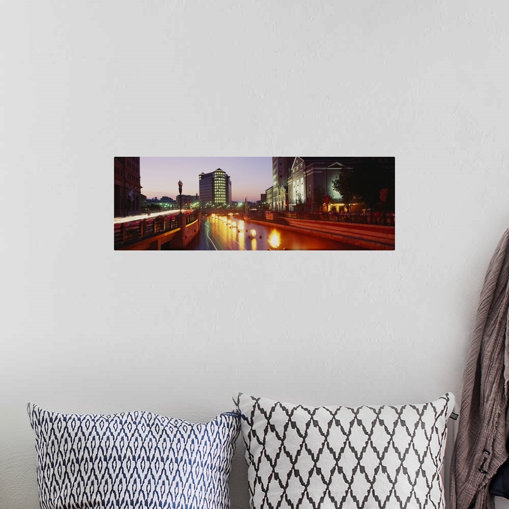 A bohemian room featuring Panoramic canvas photo of lights along a road that leads to buildings in a city at sunset.