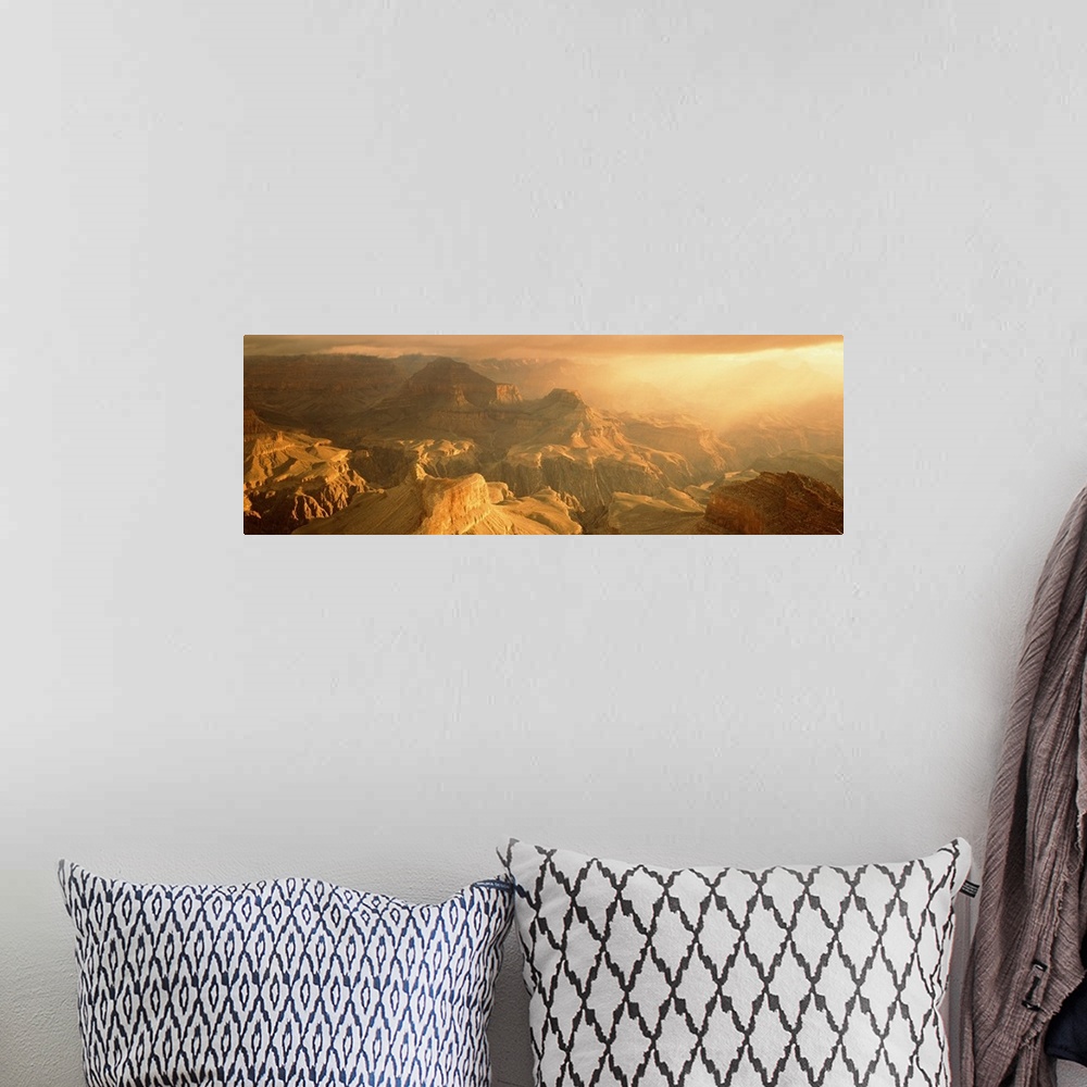 A bohemian room featuring Panoramic photo on canvas of the Grand Canyon bath in warm sunlight from a rising sun.