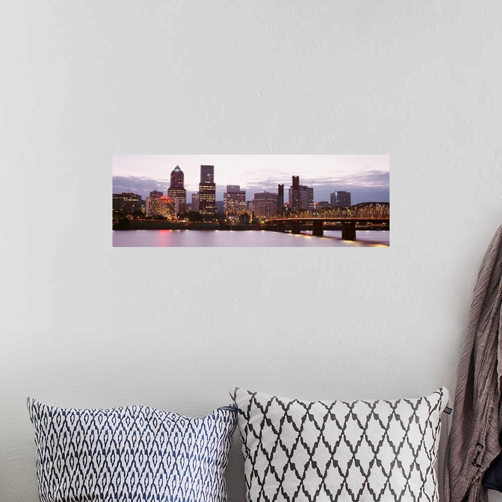 A bohemian room featuring Wide angle photograph of the Portland, Oregon skyline, lit up as the sun is setting.