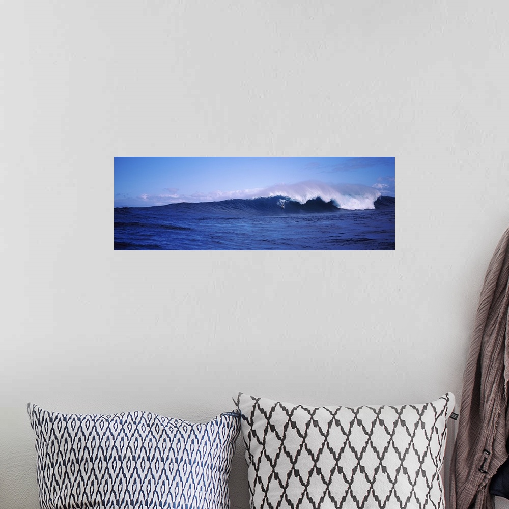 A bohemian room featuring Panoramic image of a surfer riding a large breaking wave.