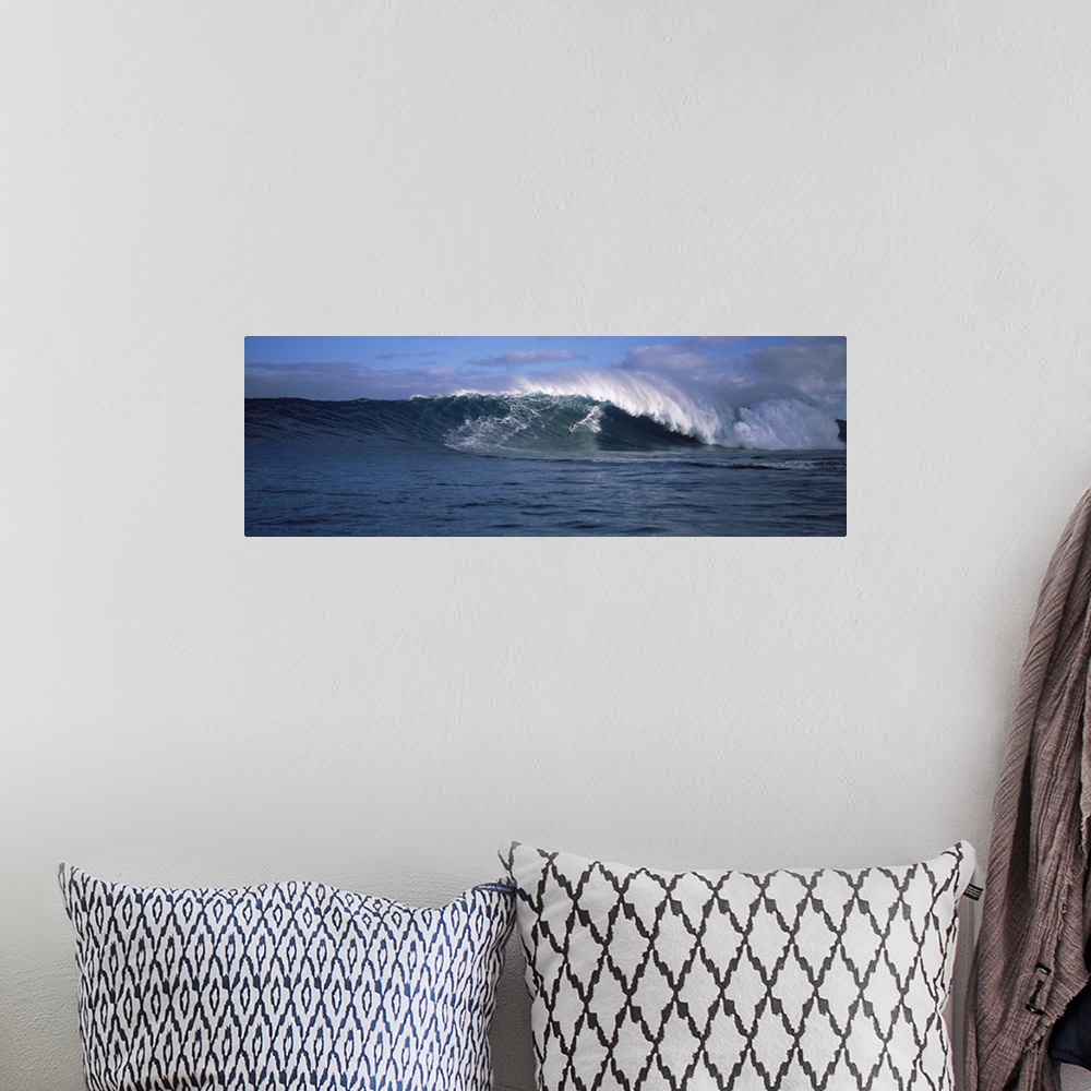 A bohemian room featuring Panoramic photo of a big wave crashing in the Pacific Ocean.