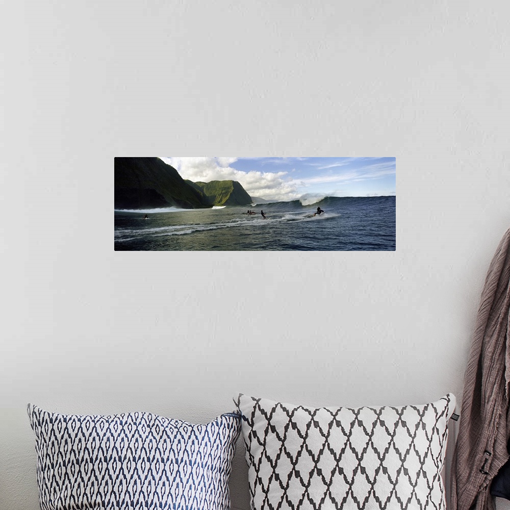 A bohemian room featuring This is a panoramic photograph of ocean swells and volcanic cliffs and surfers waiting to catch t...