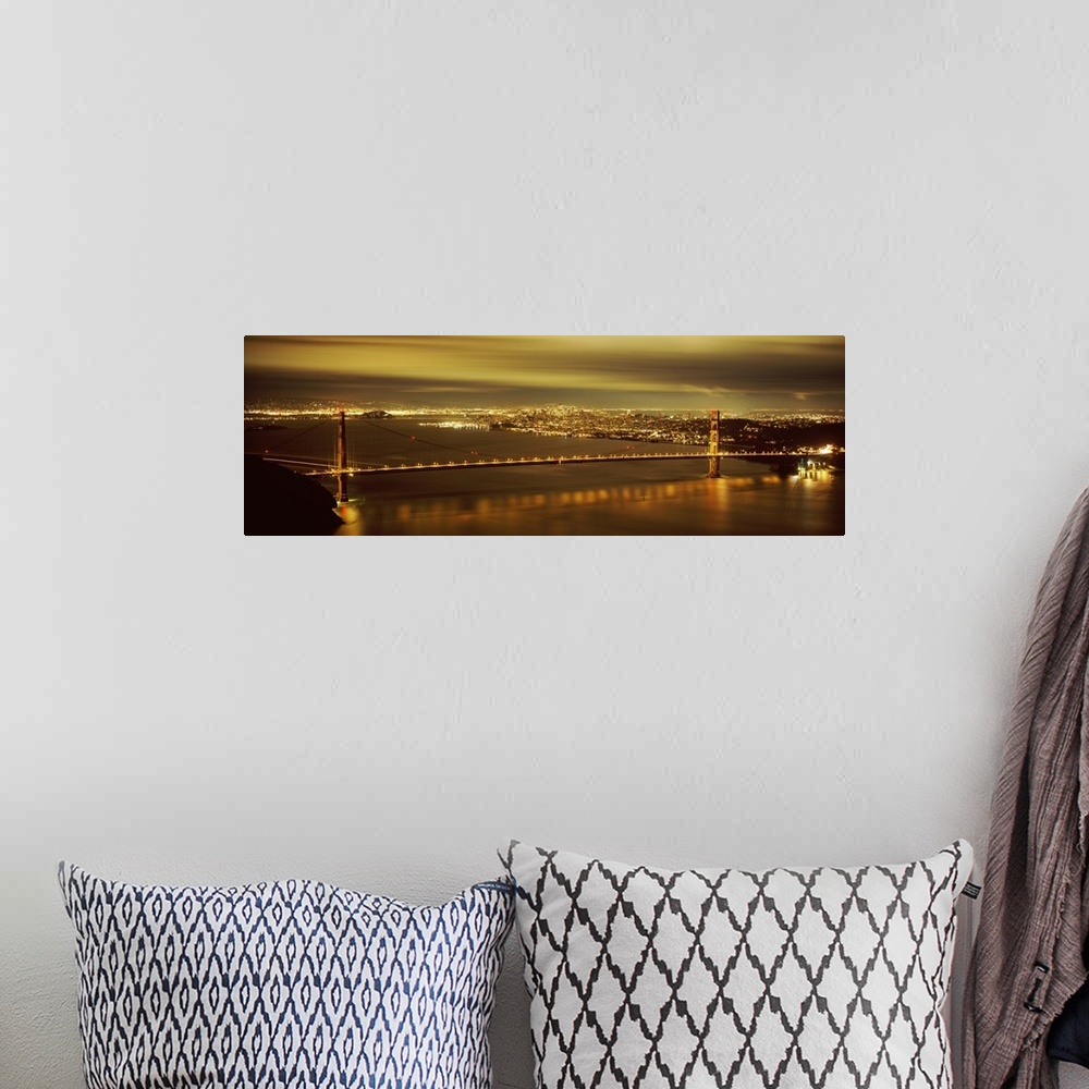 A bohemian room featuring Giant, wide angle photograph of the Golden Gate Bridge lit up at night, the city lights of San Fr...
