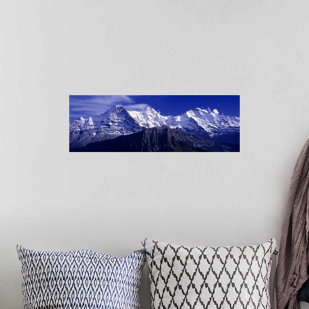 A bohemian room featuring Giant, landscape photograph of snow covered Swiss mountains against a deep blue sky in Berner, Ob...