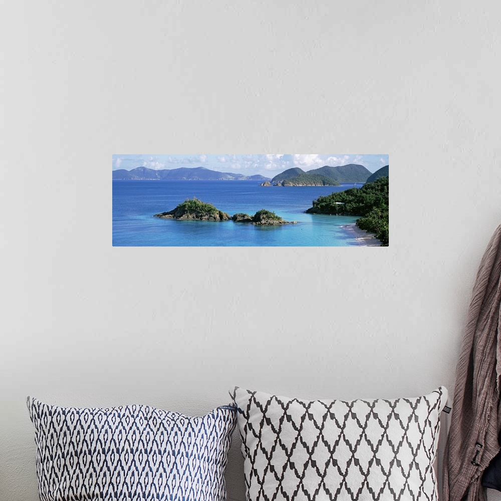 A bohemian room featuring This decorative wall is a panoramic landscape photograph of a small rocky island off the shore of...