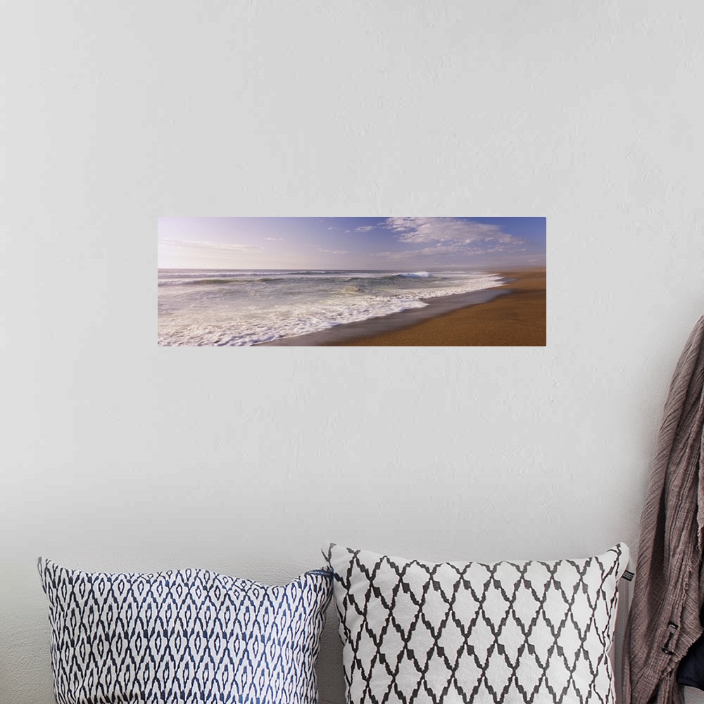 A bohemian room featuring A wide angle picture of the ocean as the water begins to rush up on the warm sand.