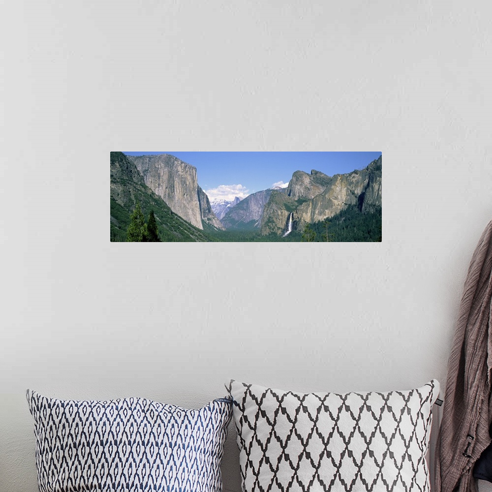 A bohemian room featuring Panoramic photograph on a big canvas of tree tops beneath a mountain landscape against a light bl...