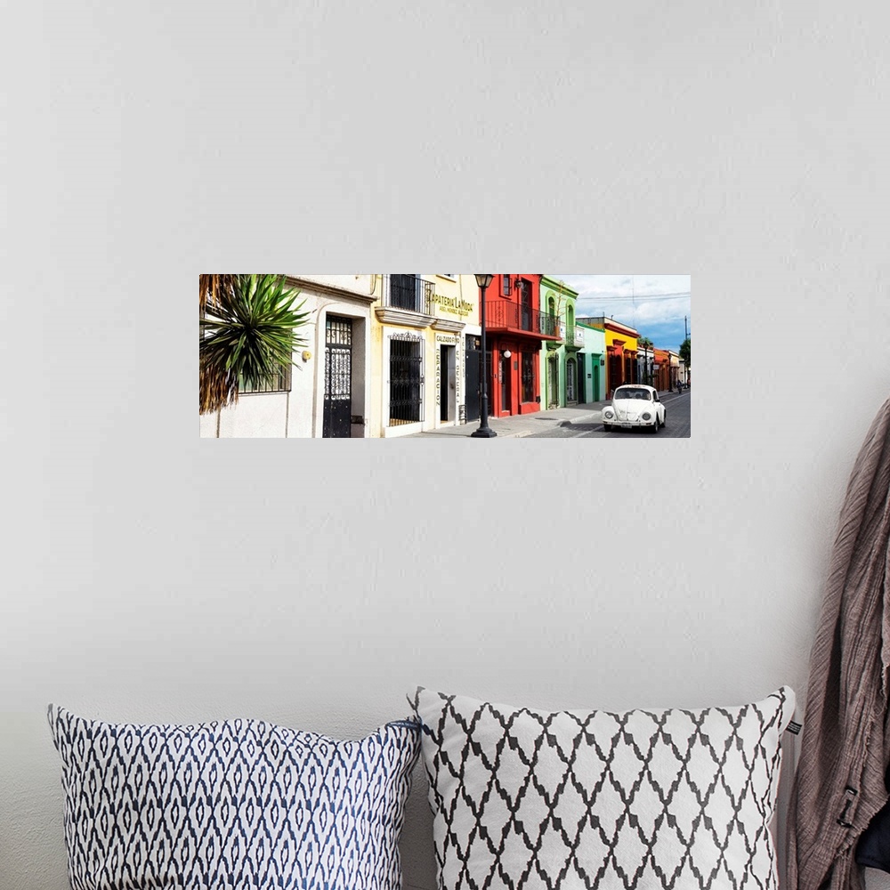 A bohemian room featuring Panoramic photograph of a classic white Volkswagen Beetle driving up a colorful street in Mexico....