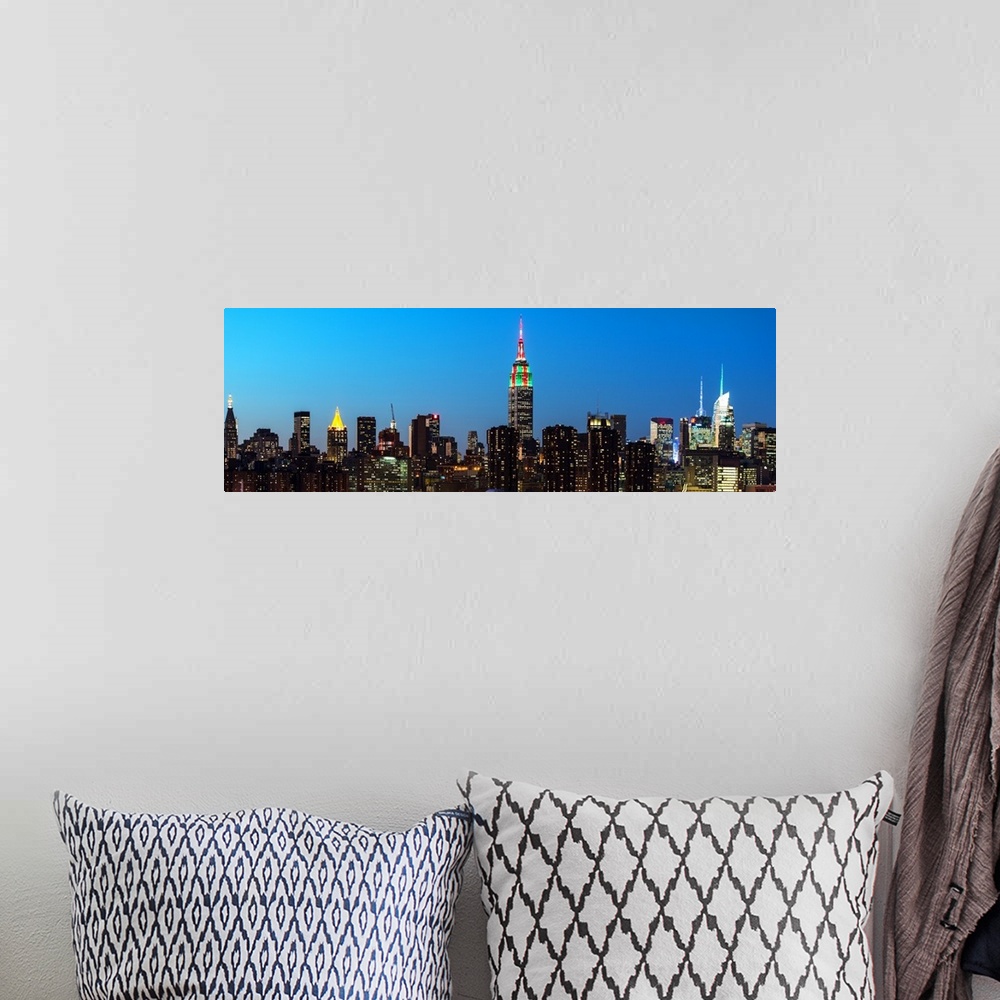 A bohemian room featuring A photograph of the New York city skyline at night, with the Empire state building standing tall.