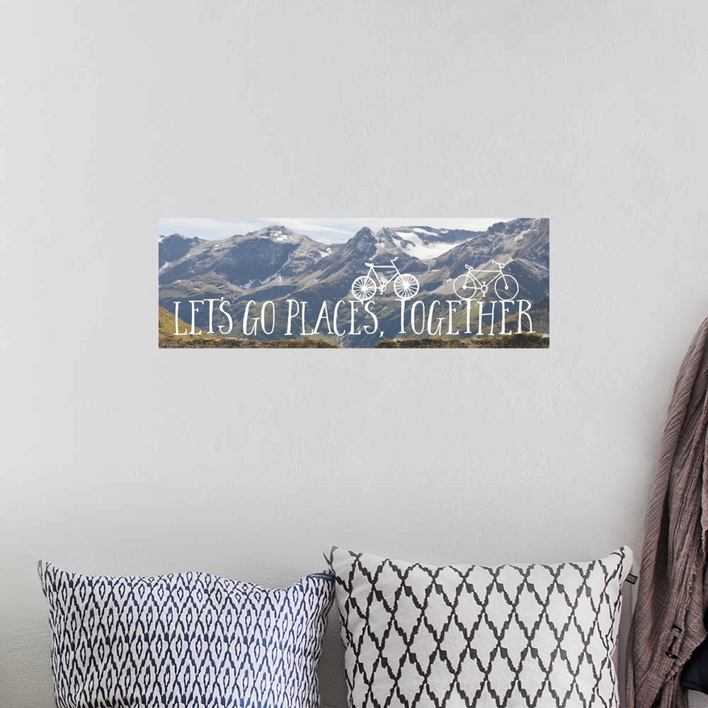 A bohemian room featuring Handwritten sentiment with two small bicycles over an image of a snowy mountain range.