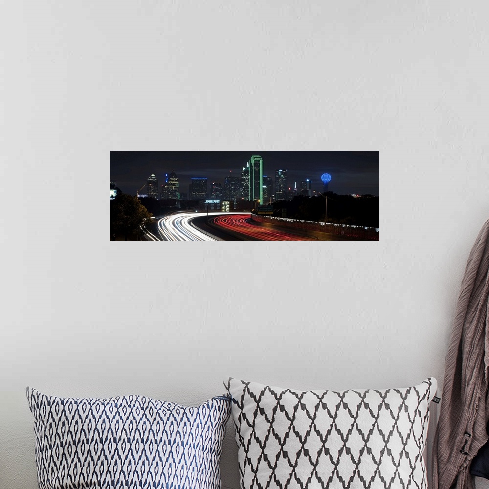 A bohemian room featuring Light trails fill the foreground with Dallas skyline in the background.