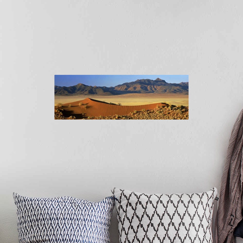 A bohemian room featuring Panoramic view over orange sand dunes towards mountains, Namibia, Africa